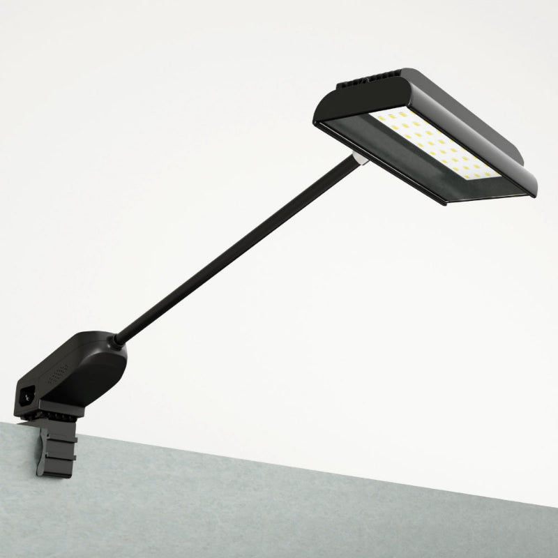 Black LED desk lamp on a white surface with a gray background